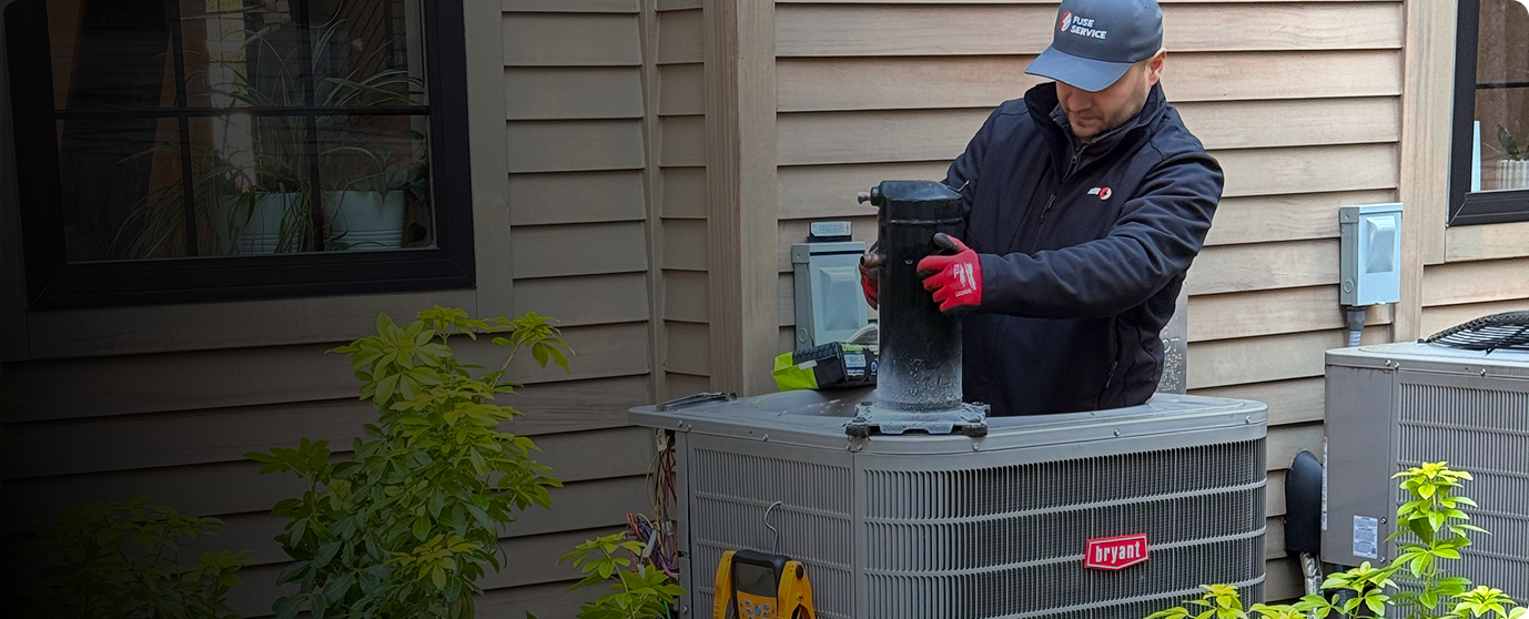 Technician connecting a replacement heat pump at a Seattle home